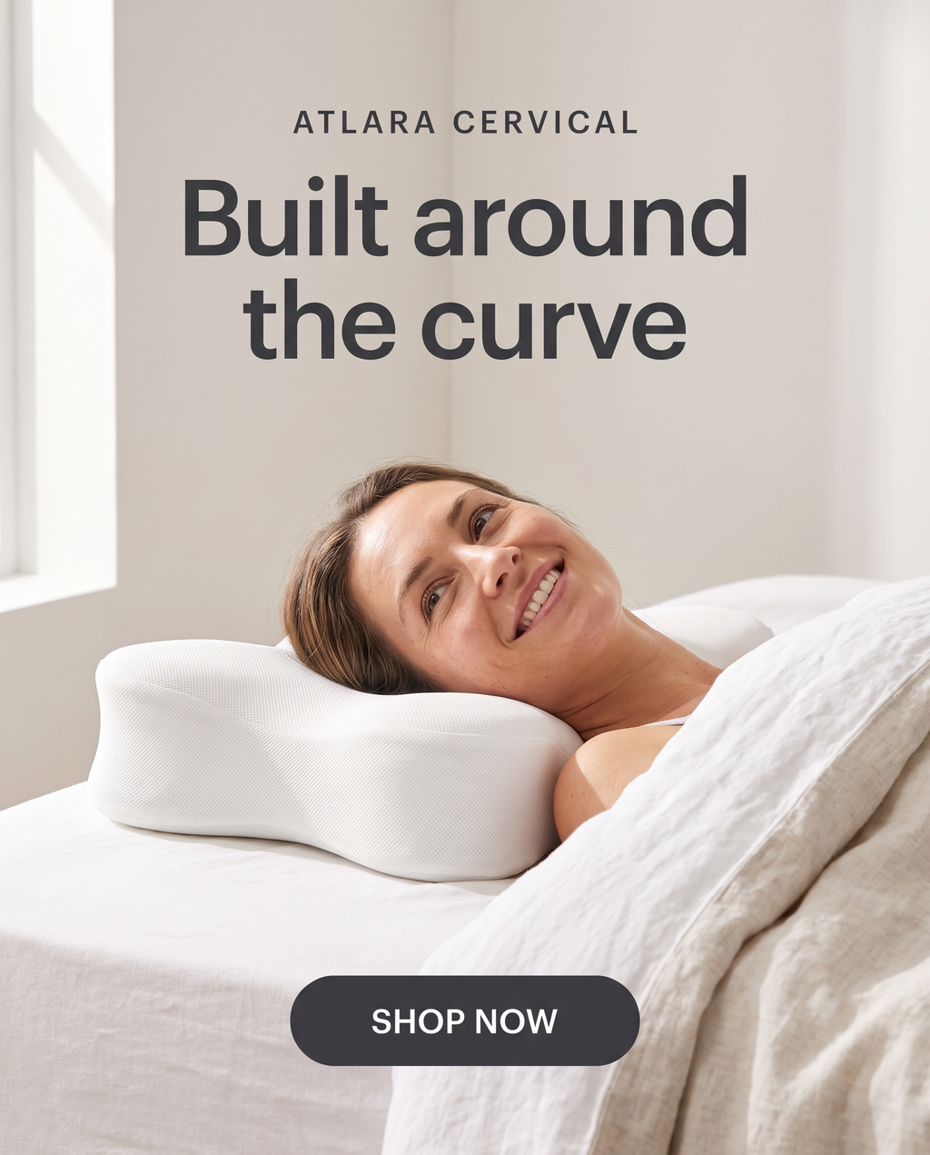 A woman waking up with her head resting in the centre of the ATLARA pillow